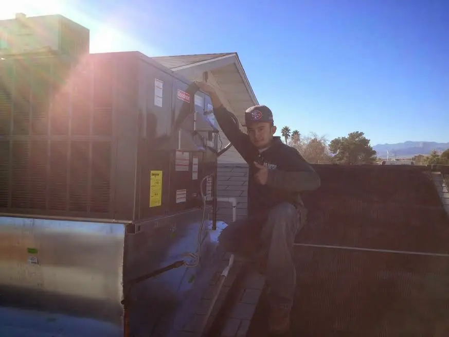 HVAC technician performing Heat Pump Repair on a rooftop unit in Orange